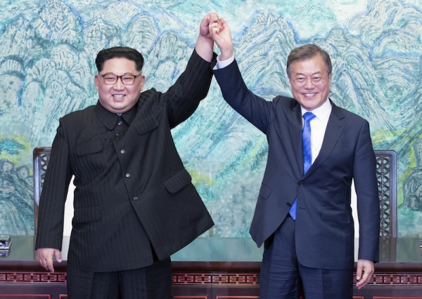 4月27日、「板門店宣言」に署名して握手を交わす韓国の文在寅大統領と北朝鮮の金正恩国務委員長。写真は板門店合同取材団。