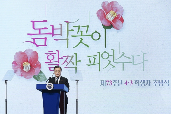 演説する文大統領。椿の花は済州4.3の象徴だ。