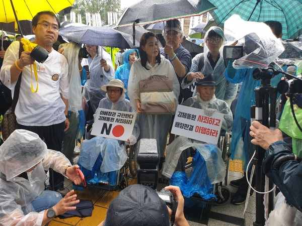 19年8月、ソウルの日本大使館前でデモを行った原告の李春植（イ・チュンシク）さん(中央右)。徐台教撮影。